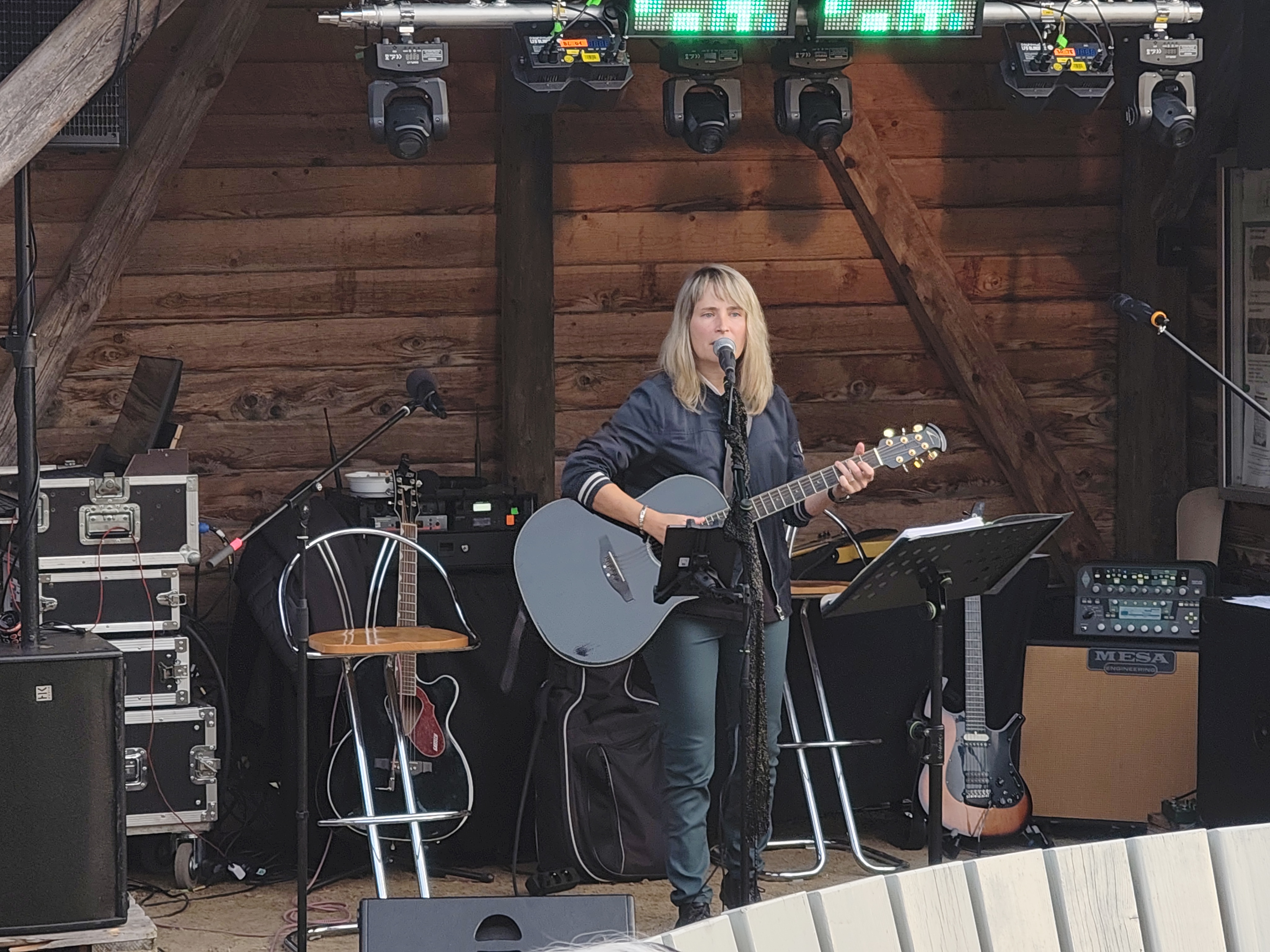 Das Bild zeigt den Auftritt von Nadine Weichenhain. Sie steht mit umgehängter Gitarre vorm Mikrofon.