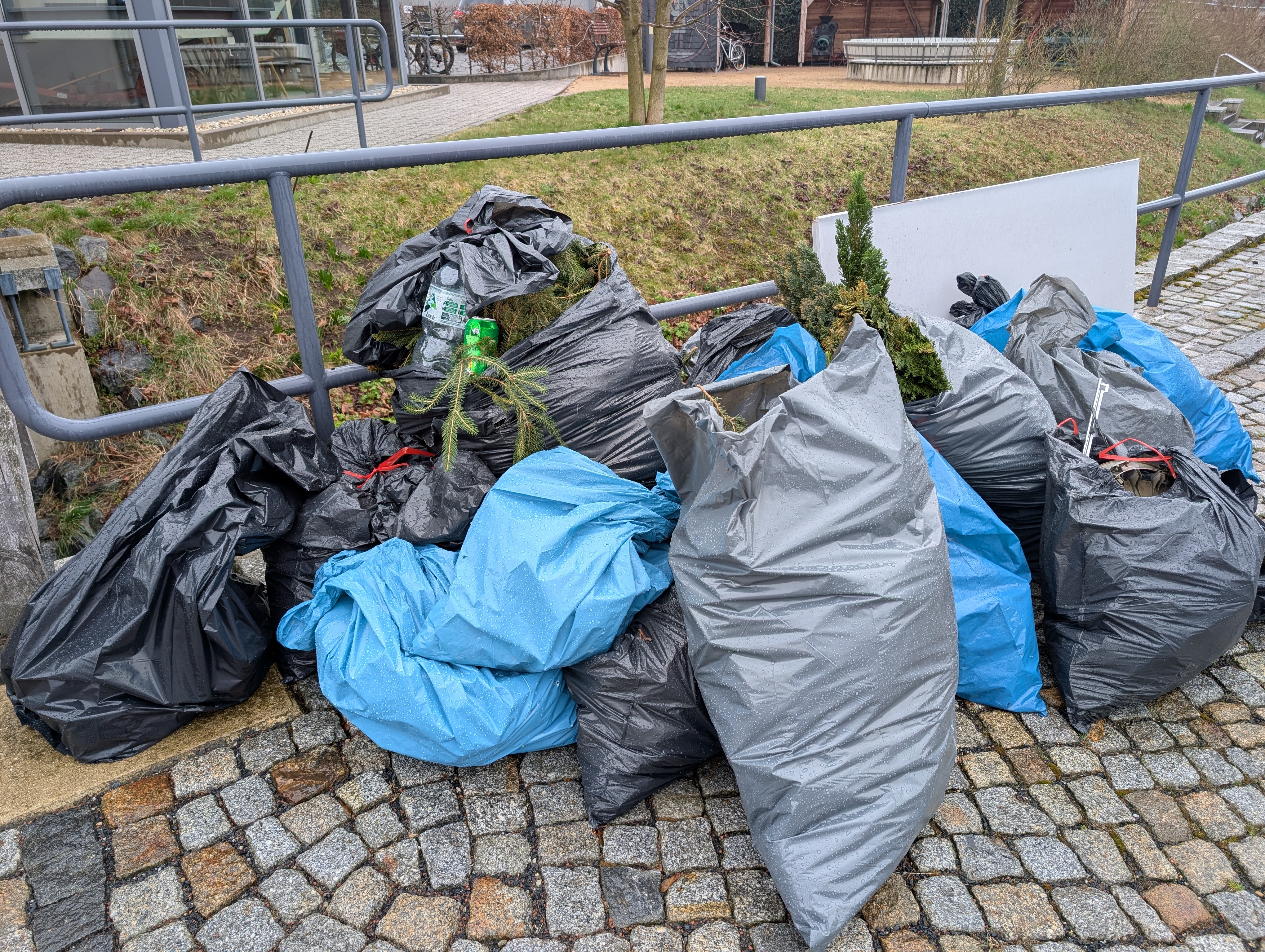 Das Bild zeigt mehrere, teils randvoll gefüllte Müllsäcke am Dorfgemeinschaftshaus in Großerkmannsdorf.